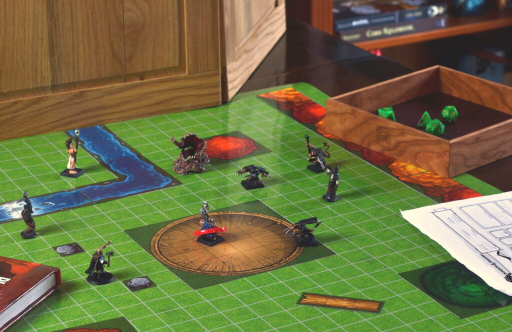 An adventuring party surrounded, by monsters and rat-men. They are battling in a crater in the woods. There is a Dice Tray on the tabletop with them.